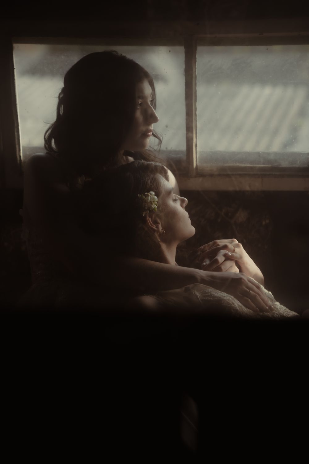 Brautpaar liegt ineinander, Hände berühren sich und beide Blicken in die Ferne